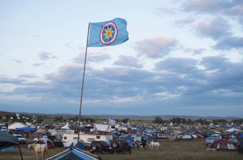 A Standing Rock Sioux flag flies over a protest encampment near Cannon Ball, North Dakota where members of the Standing Rock Sioux tribe and their supporters have gathered to voice their opposition to the Dakota Access oil Pipeline (DAPL), September 3, 2016. Drive on a state highway along the Missouri River, amid the rolling hills and wide prairies of North Dakota, and you'll come across a makeshift camp of Native Americans -- united by a common cause. Members of some 200 tribes have gathered here, many raising tribal flags that flap in the unforgiving wind. Some have been here since April, their numbers fluctuating between hundreds and thousands, in an unprecedented show of joint resistance to the nearly 1,200 mile-long Dakota Access oil pipeline. / AFP PHOTO / Robyn BECKROBYN BECK/AFP/Getty Images