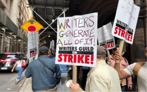 2023 writers guild strike. strikers holding signs that denounce the use of A.I. 